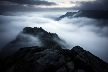 Fototapeta premium Misty mountain peak, dramatic cloudscape, high elevation, serene nature scene, landscape photography