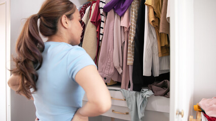 Asia woman people anger shock sad tired used dirty heap clothes neat arrange clean house room. Asian wife home chores open dresser rack look at old closet stack fabric garment fast fashion waste issue