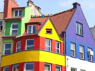 Fototapeta premium Vibrant building with rainbow roof design standing out in urban landscape, multicolored, exterior, vibrant colors