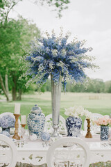 Beautiful floral arrangement on a white table set in an outdoor garden during a spring event