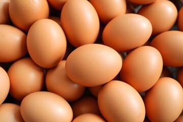 A detailed close-up image of numerous fresh brown eggs stacked together