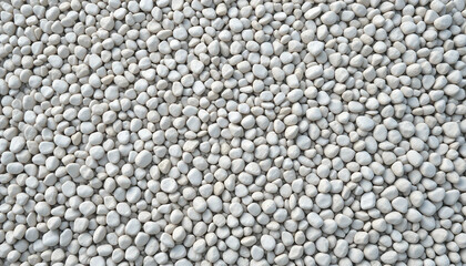 Top view shot of a vast, textured surface covered in small, smooth white pebbles stones, creating a serene and natural stone background. Suitable for marketing or business purposes