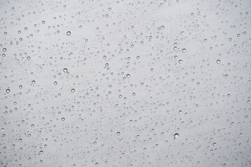 gotas de lluvia texturizando ventana de vidrio transparente con fondo de cielo gris