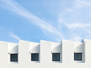 Clean and modern contemporary white real estate building with clear blue sky. Minimalist photography.