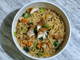 Soy sauce fried noodles served with pickles, chilies, vegetables, etc.