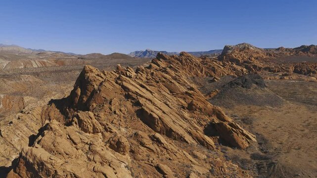 HURRICANE, UTAH, USA - February 07, 2025: Aerial-Flying over red rock sandstone up tilted formation under blue sky