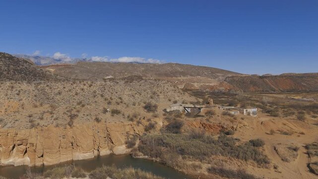 VIRGIN RIVER, UTAH, USA - February 07, 2025: Aerial-Descending-Stormont Silver Mill-Babylon house ruins and the small flow of the Virgin River 