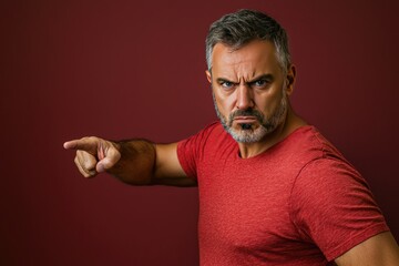 Fototapeta premium Angry man in red shirt points accusingly