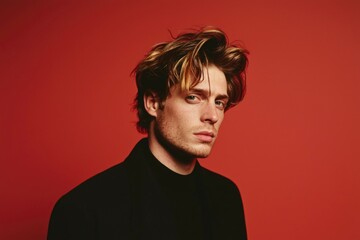 Fototapeta premium Man portrait Intense gaze on red backdrop evokes strength and emotion. Stock photo