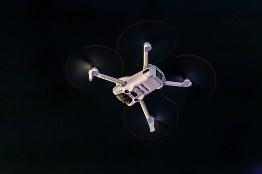 White drone flying at night