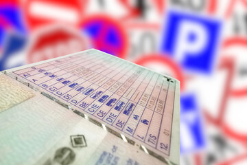Fototapeta premium Viele verschiedene Verkehrsschilder und ein Führerschein