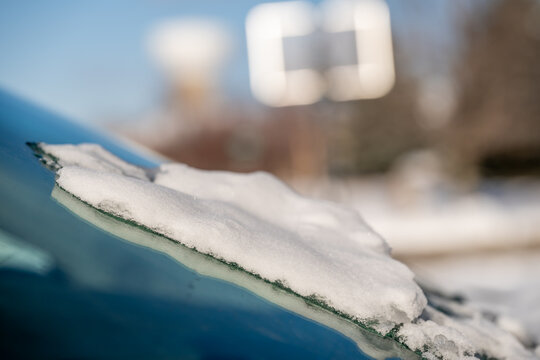 ice and snow on the front windshield of a vehicle.