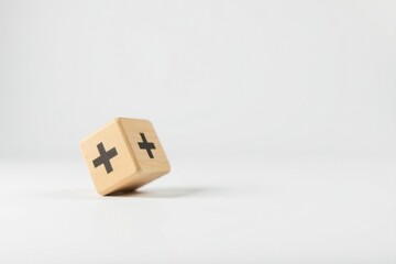 Wooden block with plus symbol, leaning against a plain white background, signifying addition, positivity, or growth