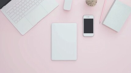 Flat lay of an open laptop and phone on a pastel pink desk with office supplies, highlighting a minimalist workspace for productivity.
