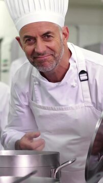 Head chef smelling pot of soup making ok sign