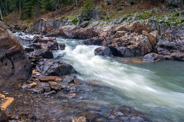 Fototapeta premium Water autumn landscape. A shallow fast mountain river with a rocky bottom. Ural.