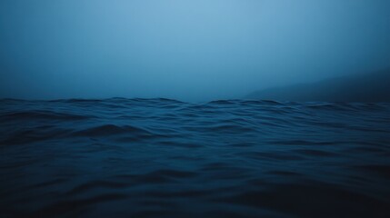 Obraz premium Serene Blue Ocean Waves in Misty Foggy Atmosphere at Dusk