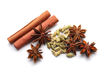 Star anise with cinnamon sticks and cardamom seeds on white background, top view