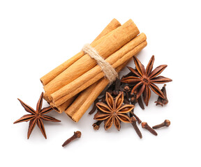 Star anise with cinnamon sticks and cloves on white background, top view