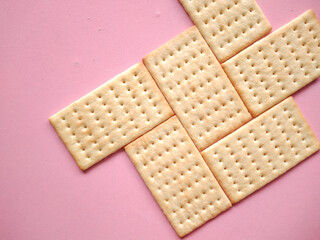 Salty crackers. The crackers have a crisp, slightly flaky texture with small perforations on the top surface. 