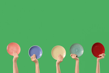 Female hands with different plates on green background