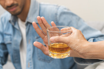 Alcoholism, depressed asian young man refuse, push out alcoholic beverage glass, drink whiskey,...