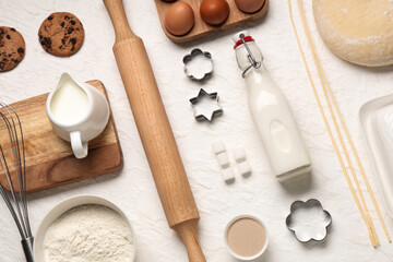 Composition with wooden rolling pin and ingredients for dough on white background