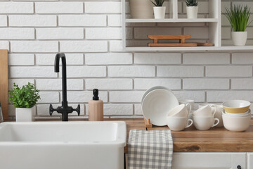 Clean dishes on wooden kitchen counter near sink