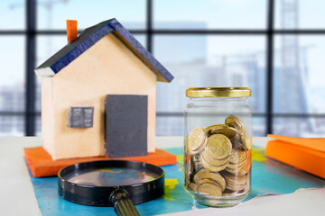 Real Estate Investment and Savings Concept with Model House and Jar of Coins