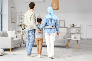 Happy Muslim family hugging at home, back view