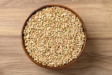 Organic buckwheat seed in bowl on wooden background, Food ingredient, Table top view