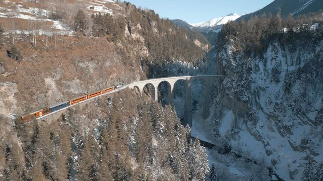Die R&auml;htische Bahn f&auml;hrt mit einem Zug &uuml;ber das traumhaft sch&ouml;ne Landwasserviadukt
