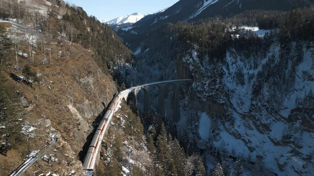 Die R&auml;htische Bahn f&auml;hrt mit einem Zug &uuml;ber das traumhaft sch&ouml;ne Landwasserviadukt