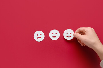 Male hand and rating smiles on red background. Survey concept