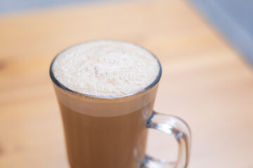 Thai tea in glass milk hot water breakfast background show wood table top with food art, cup of coffee milky latte foam leaf, as drink isolated on a light cozy christmas bar.