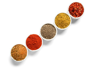 Row of bowls with different spices on white background