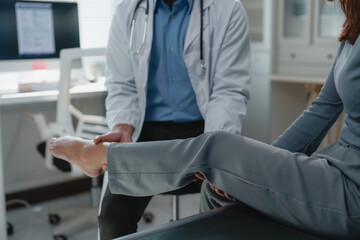 Doctor carefully examining a female patient's leg, providing personalized healthcare and addressing...