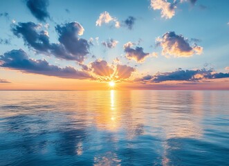 Beautiful sunrise over the sea, blue sky with fluffy clouds and the sun in the morning, a panoramic view of the calm water surface, a tranquil nature background. This is a stock photo