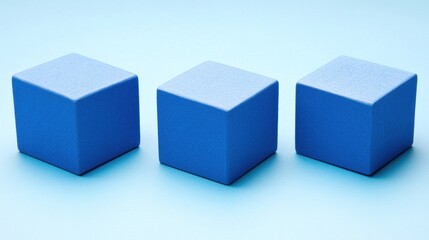 Fototapeta premium Three blue cubes arranged in a row on a light blue background.