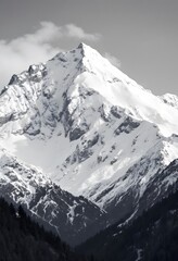 Obraz premium Snowy Mountain Peak Against Cloudy Sky in Monochrome Alpine Landscape
