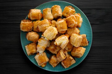 Golden-brown puff pastries on a teal plate.