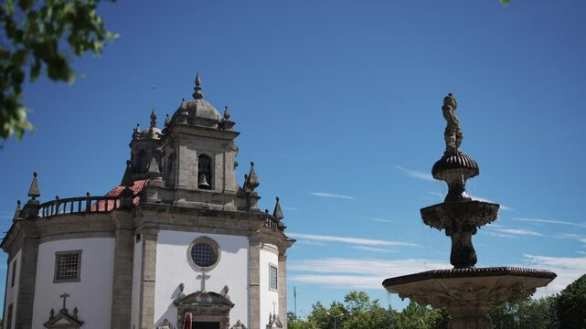 Senhor da Cruz Church and historic fountain in Barcelos, Portugal, under a blue sky