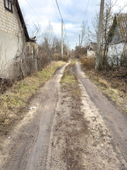 A dirt road with a house in the background