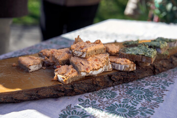 Fototapeta premium Assorted bread slices with spreads on rustic wooden platter