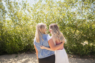 Fototapeta premium Two girls embracing outside at the park