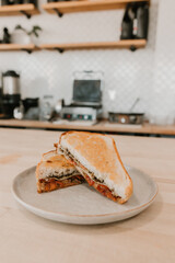 Grilled sandwich with pesto and tomatoes on a plate in cafe setting