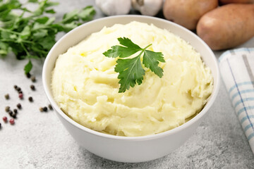 Mashed potatoes in white bowl on grey concrete background. Healt