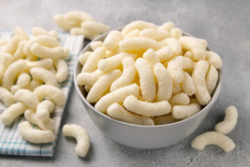 Air corn sticks in a ceramic plate on a gray background.