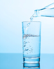 Crystal clear water being poured into a transparent glass, creating refreshing ripples and bubbles