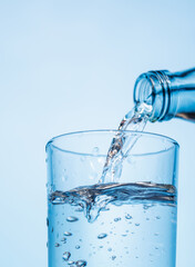 Crystal clear water being poured into a transparent glass, creating refreshing ripples and bubbles